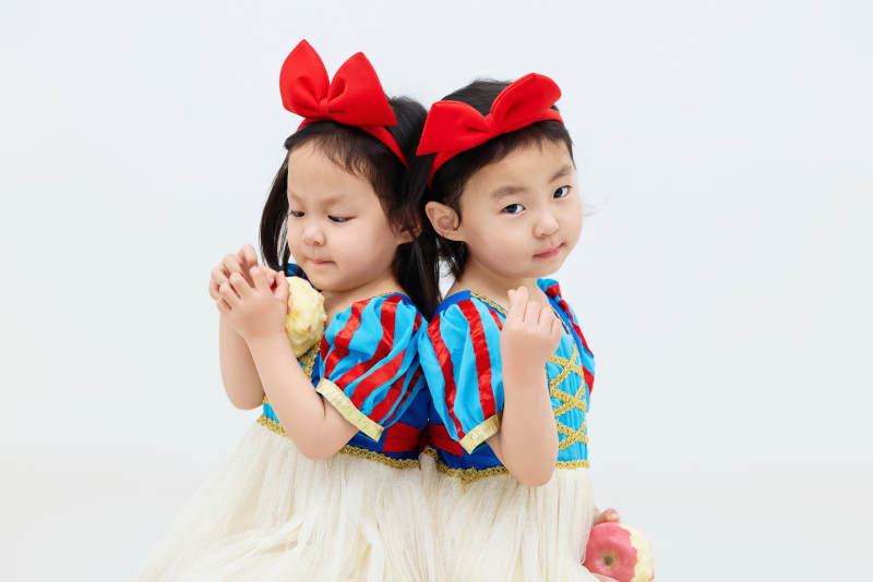 白色背景下顽皮可爱的双胞胎小女孩图片