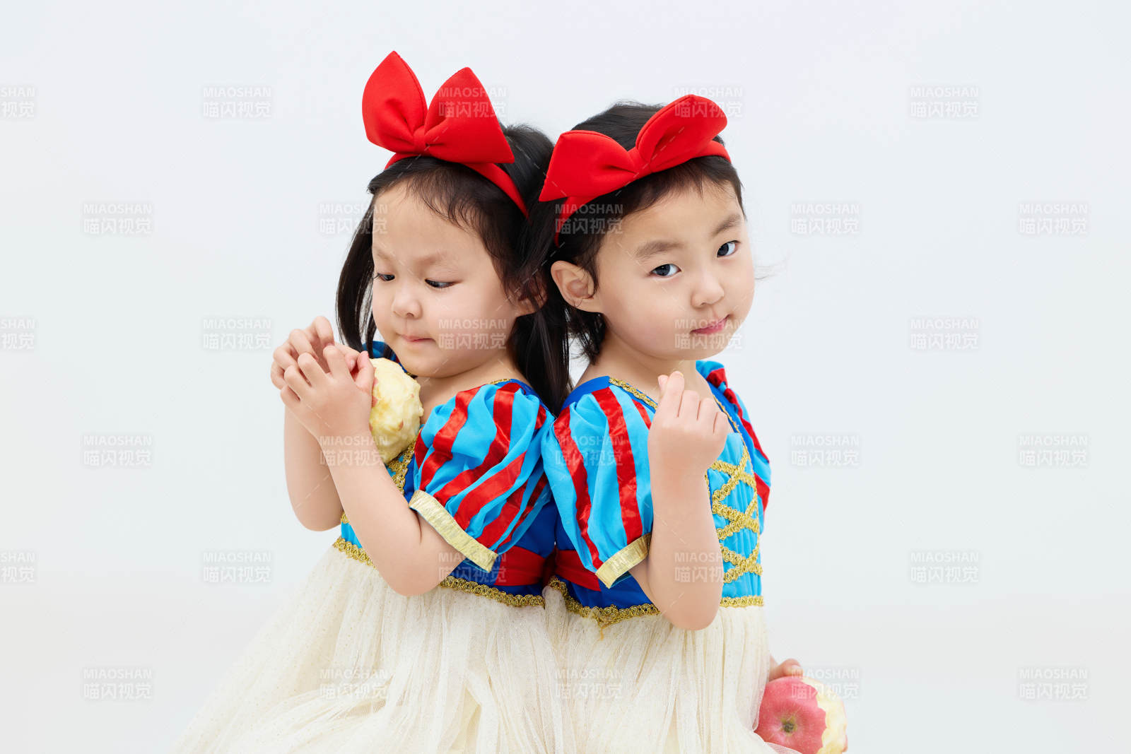 白色背景下顽皮可爱的双胞胎小女孩图片