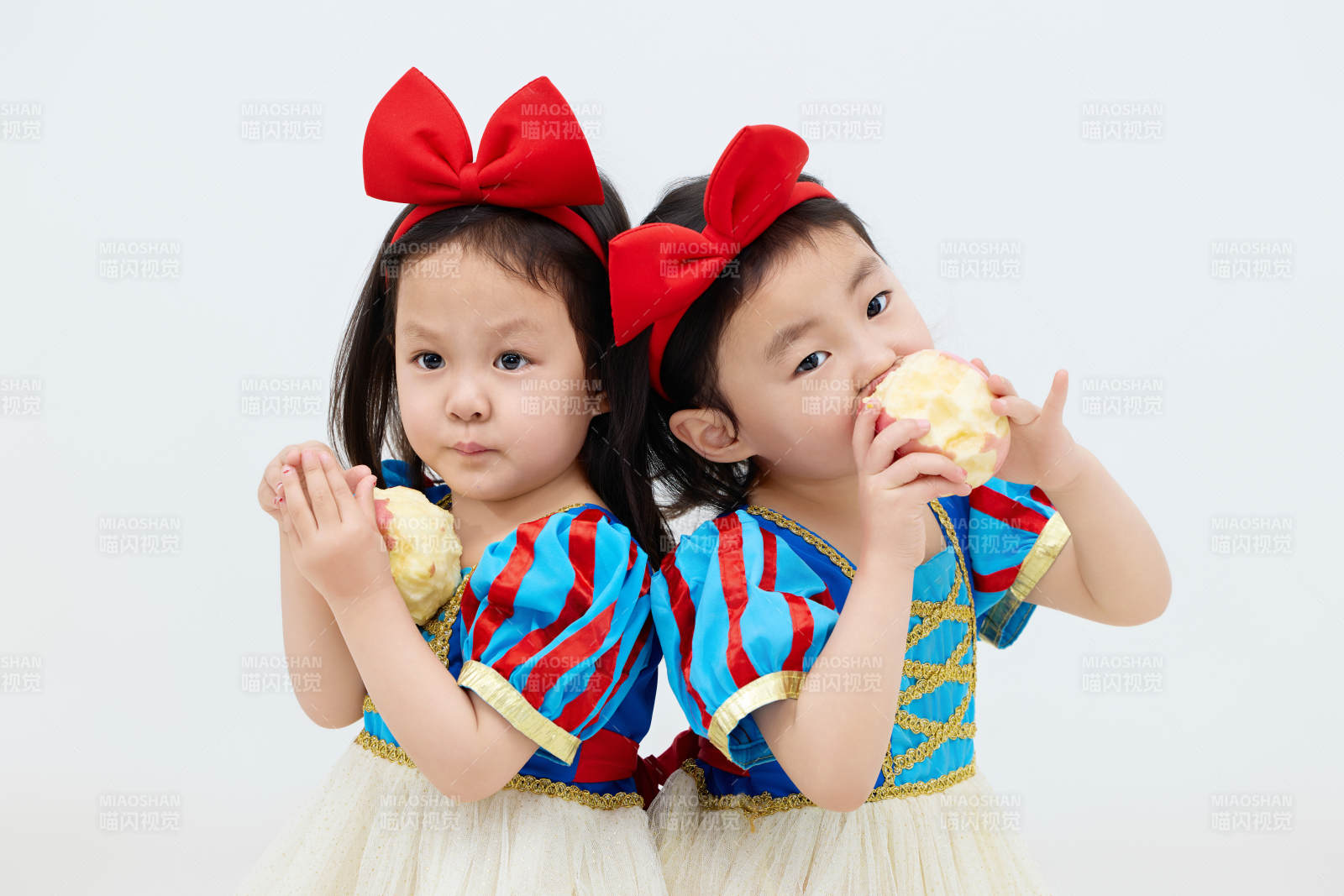 白色背景下顽皮可爱的双胞胎小女孩图片