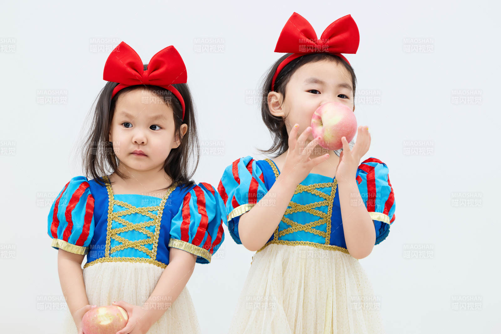 白色背景下顽皮可爱的双胞胎小女孩图片