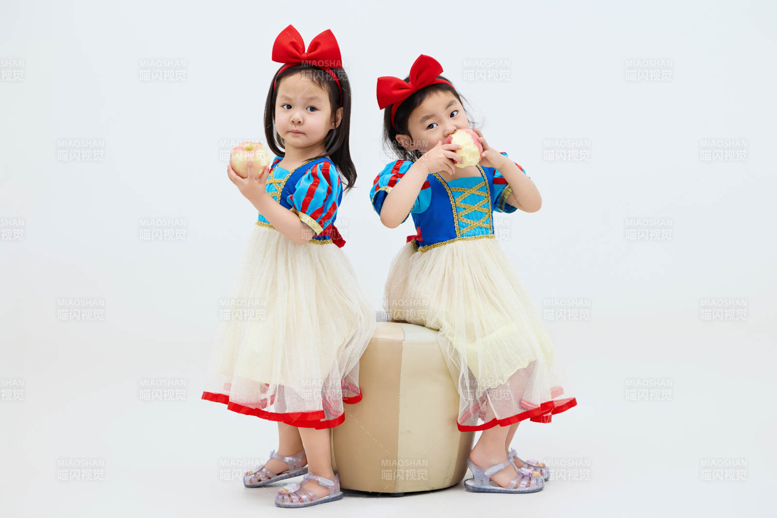 白色背景下顽皮可爱的双胞胎小女孩图片