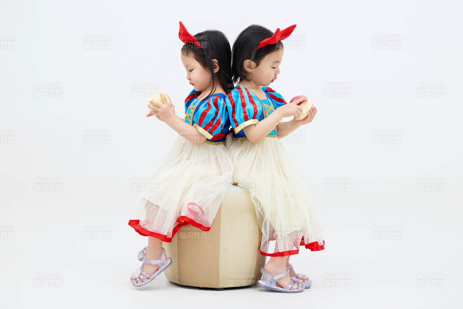白色背景下顽皮可爱的双胞胎小女孩图片