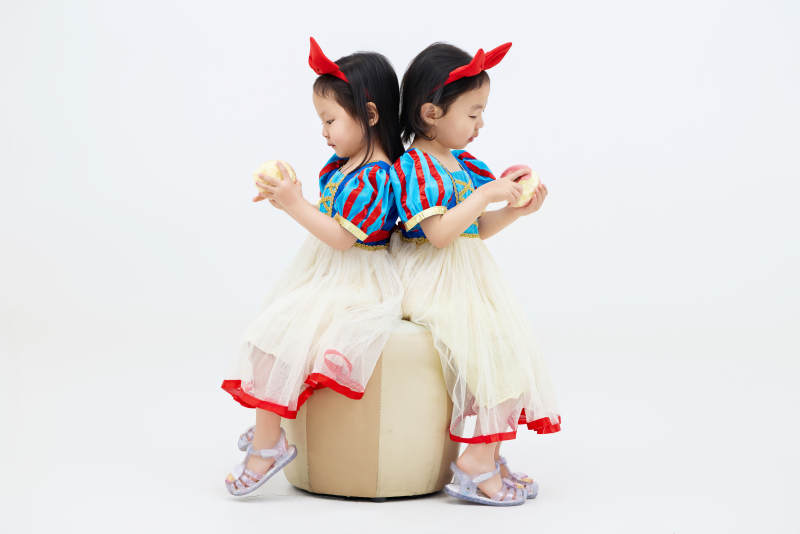 白色背景下顽皮可爱的双胞胎小女孩图片