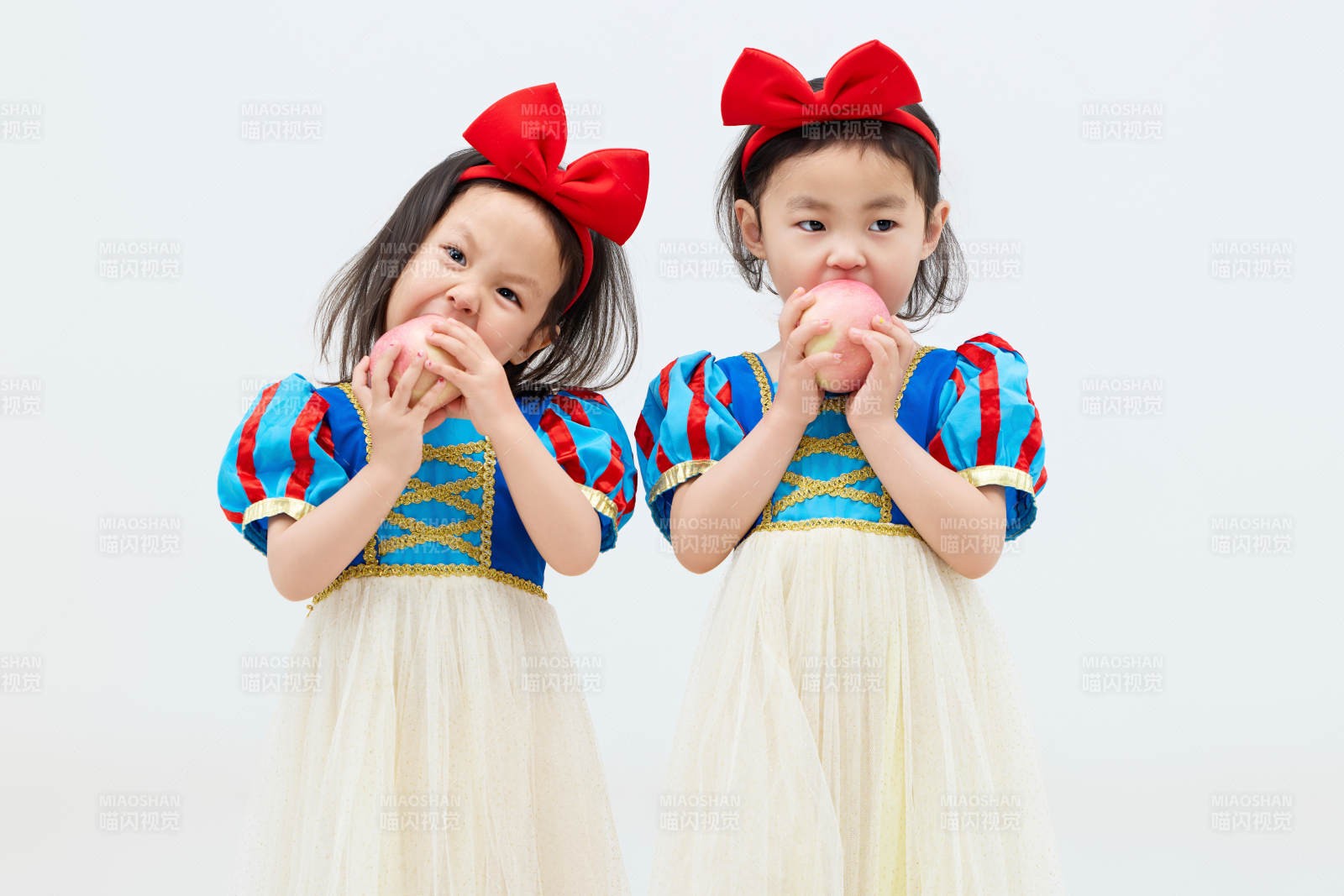 白色背景下顽皮可爱的双胞胎小女孩图片