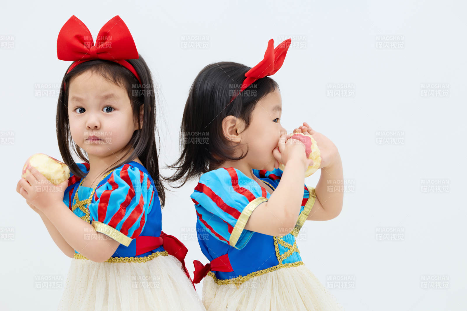 白色背景下顽皮可爱的双胞胎小女孩图片