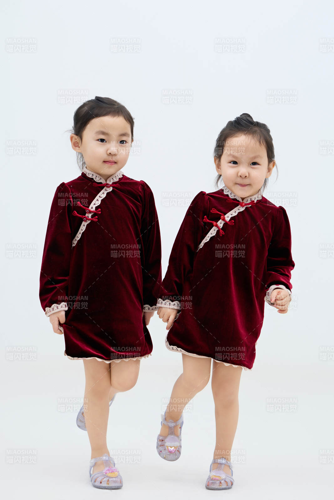 白色背景下顽皮可爱的双胞胎小女孩图片