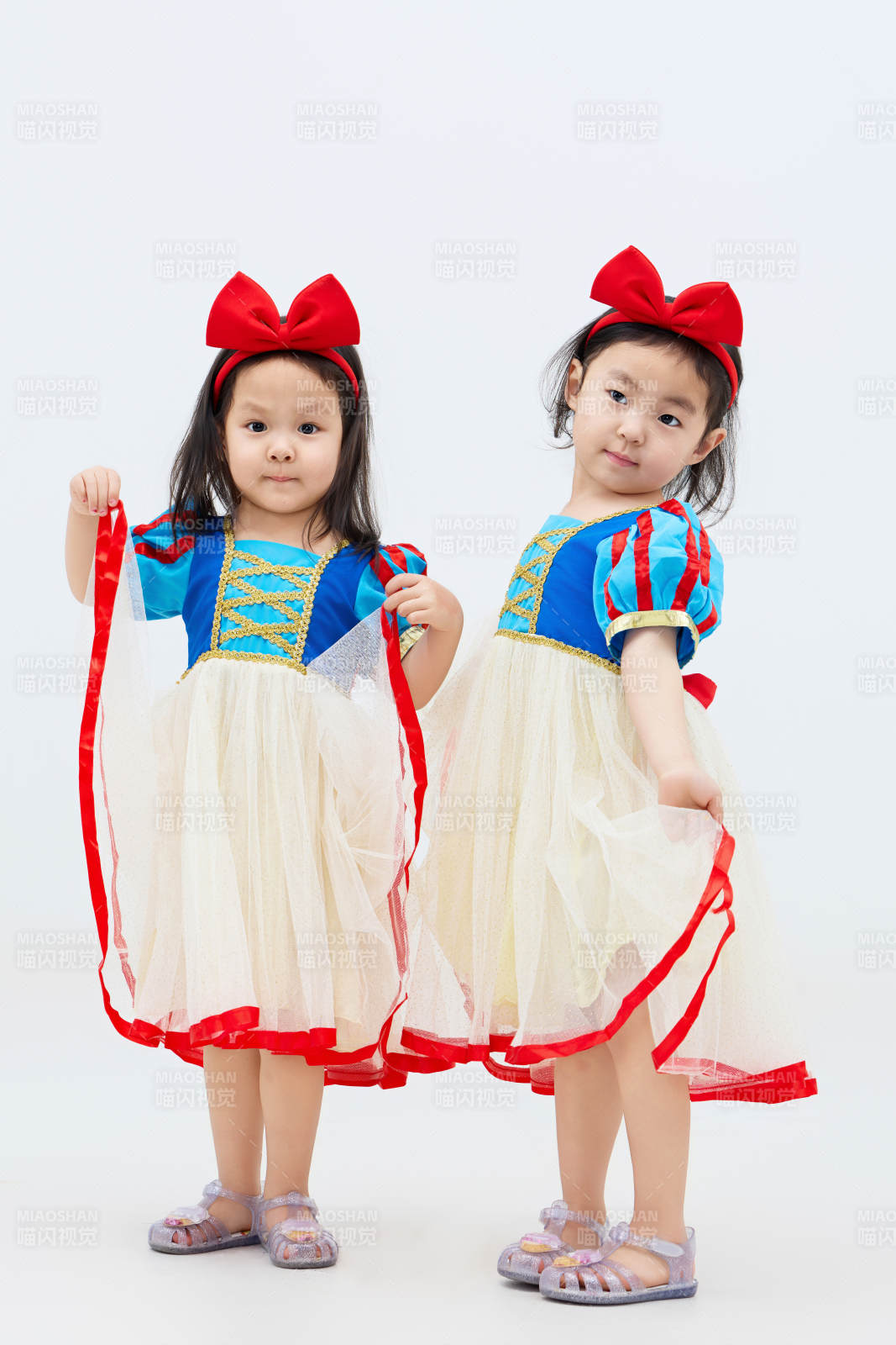 白色背景下顽皮可爱的双胞胎小女孩图片