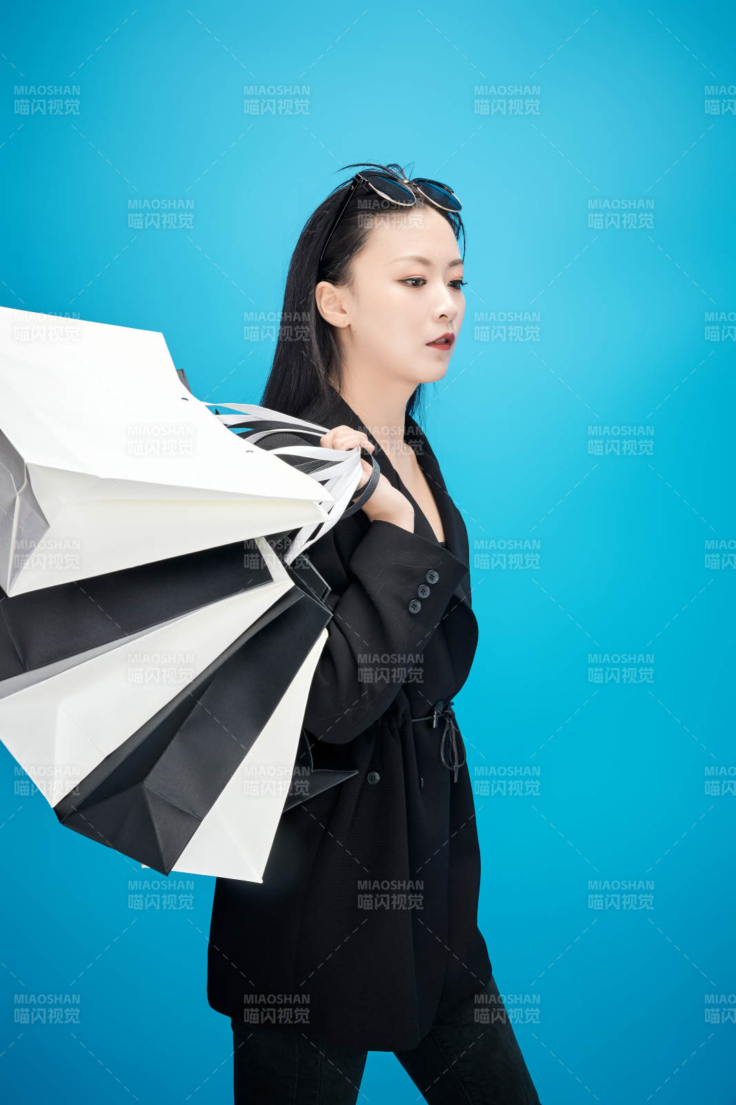 青蓝色背景下手提购物袋的亚洲时尚少女图片