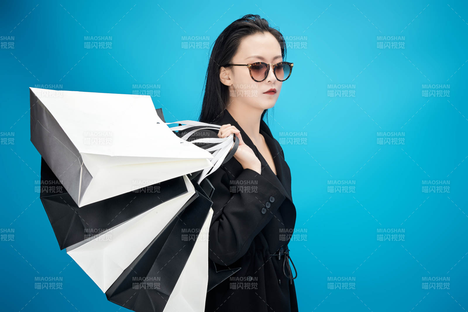 青蓝色背景下手提购物袋的亚洲时尚少女图片