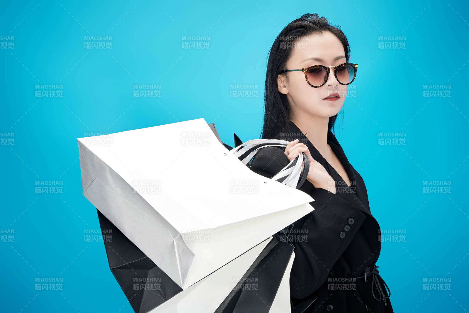 青蓝色背景下手提购物袋的亚洲时尚少女图片