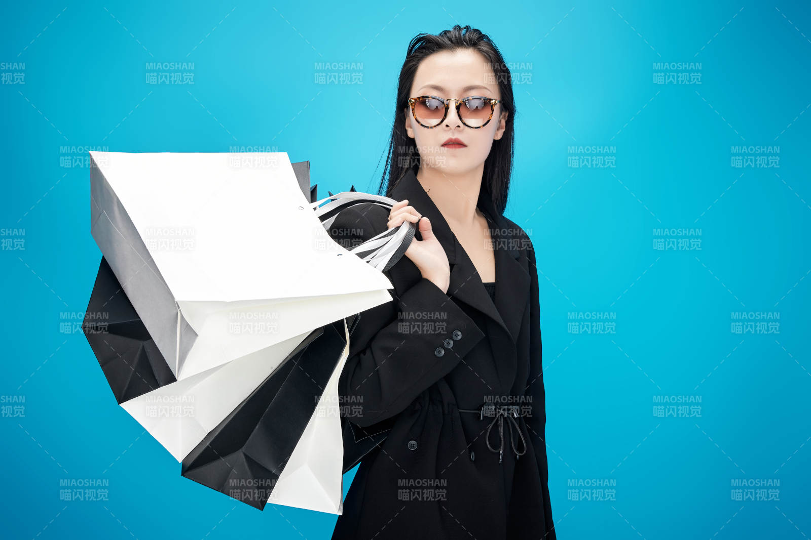 青蓝色背景下手提购物袋的亚洲时尚少女图片