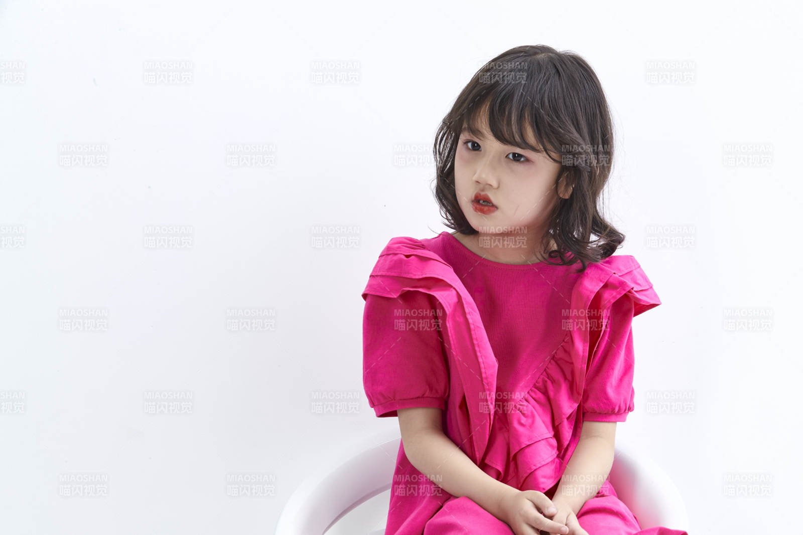 白色背景里坐在凳子上的可爱的亚洲小女孩儿童图片