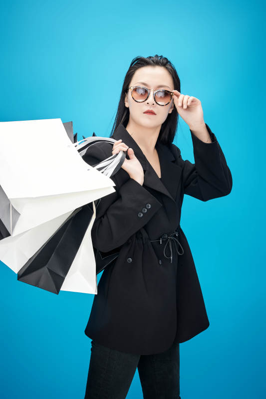 青蓝色背景下手提购物袋的亚洲时尚少女图片