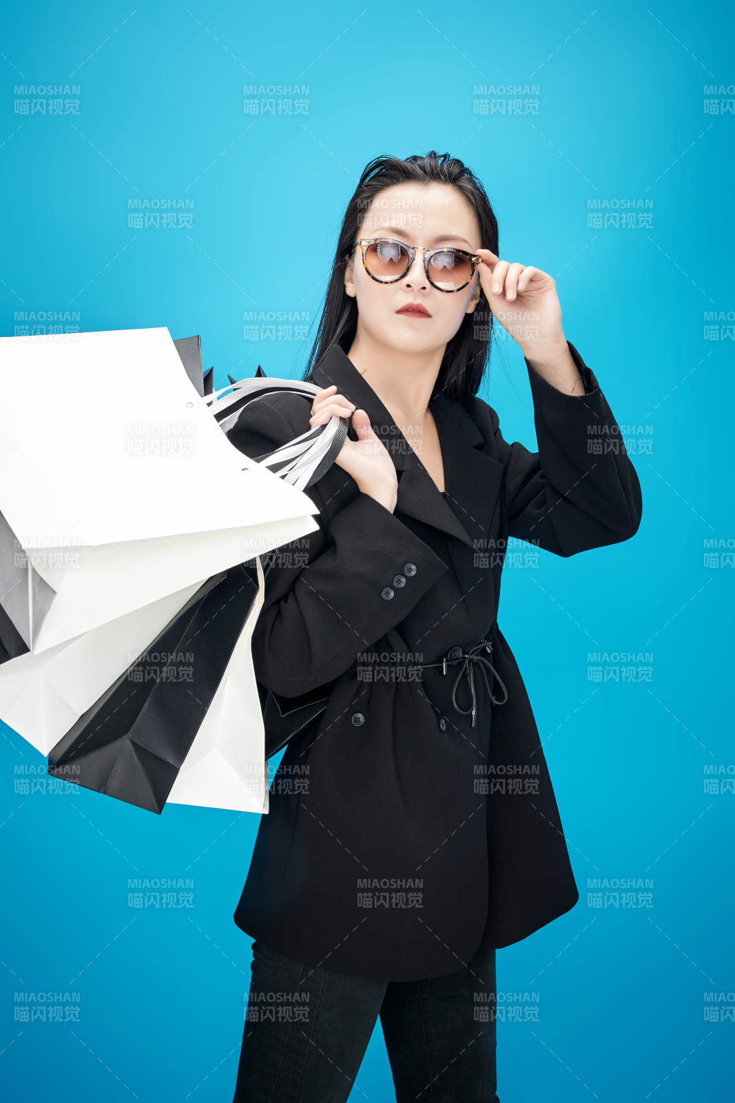 青蓝色背景下手提购物袋的亚洲时尚少女图片