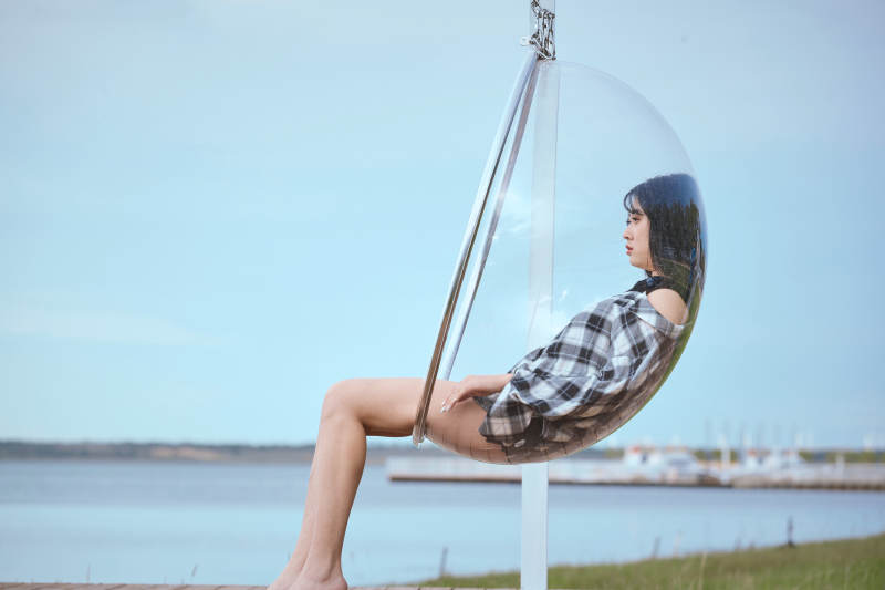 草原湖畔坐在透明秋千里的亚洲年轻女性人像图片