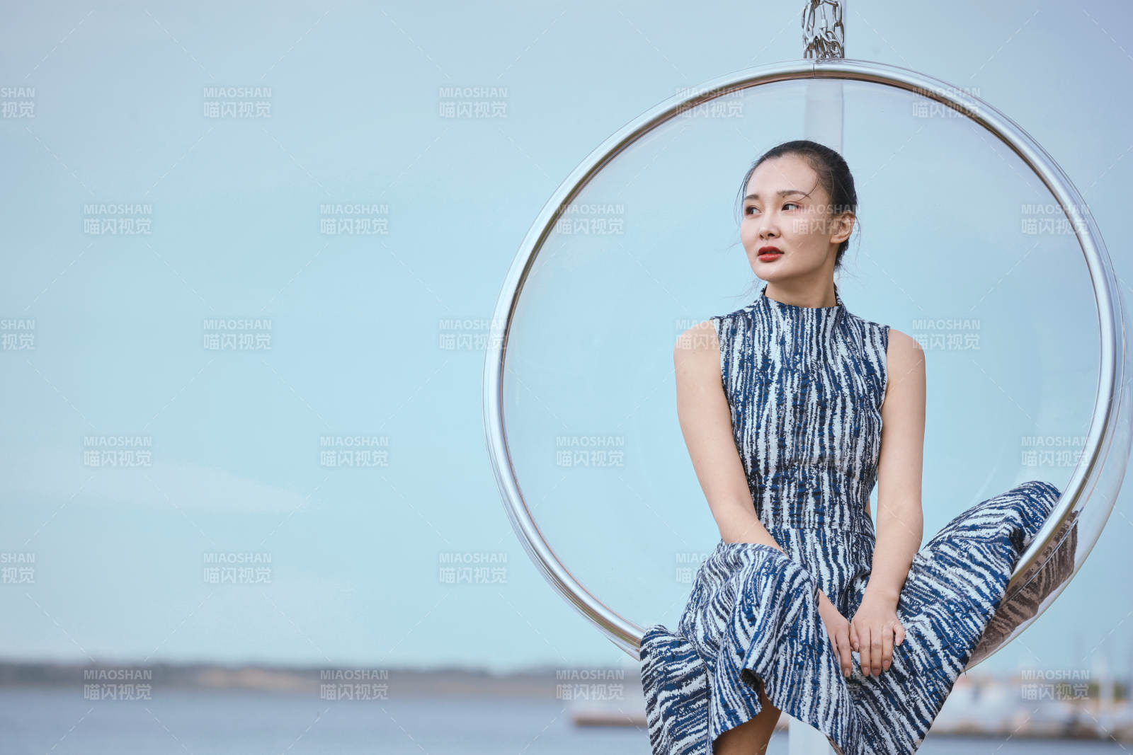 草原湖畔坐在透明秋千里的亚洲年轻女性人像图片