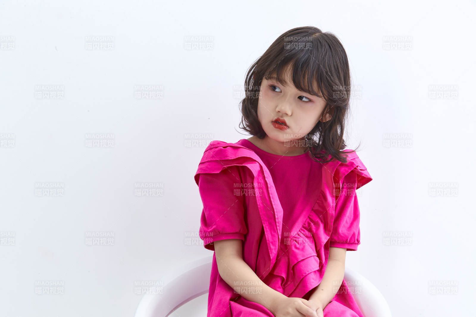 白色背景里坐在凳子上的可爱的亚洲小女孩儿童图片