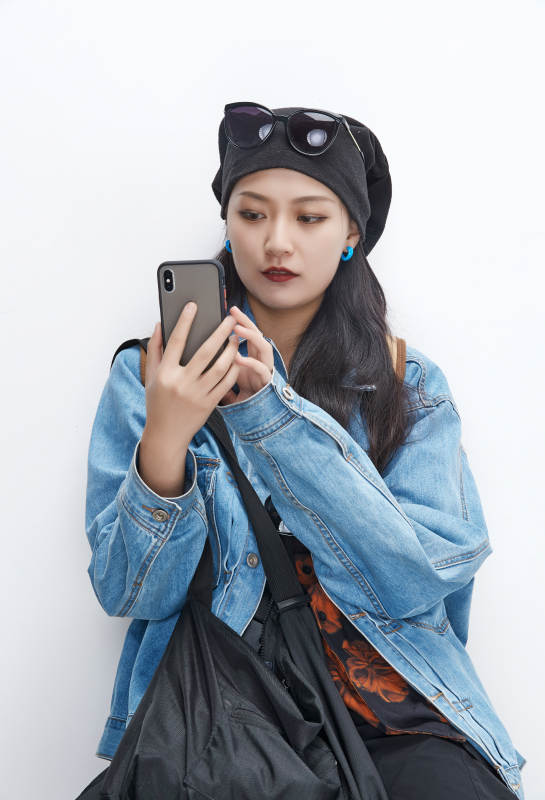 手里拿着手机准备出发的美丽东方女孩图片