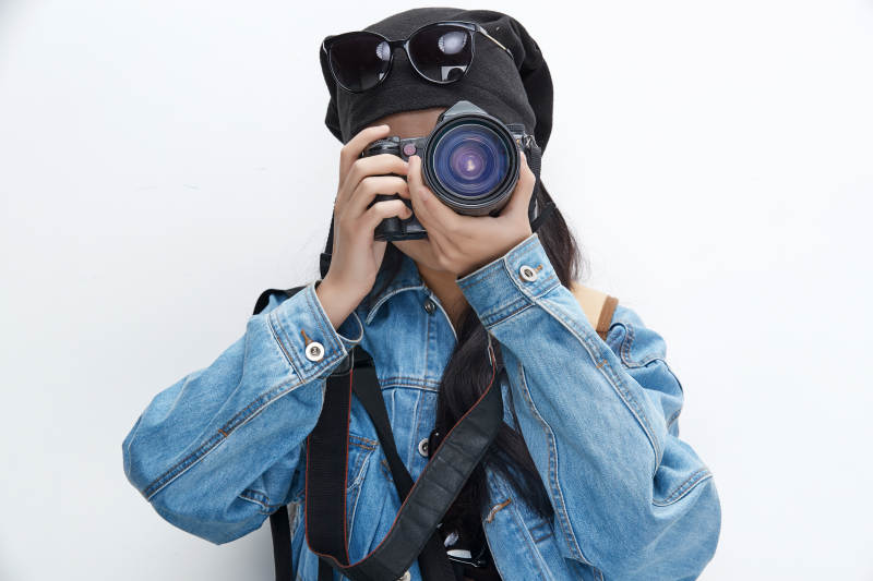 出门旅行手上拿着单反相机的美丽亚洲女孩图片