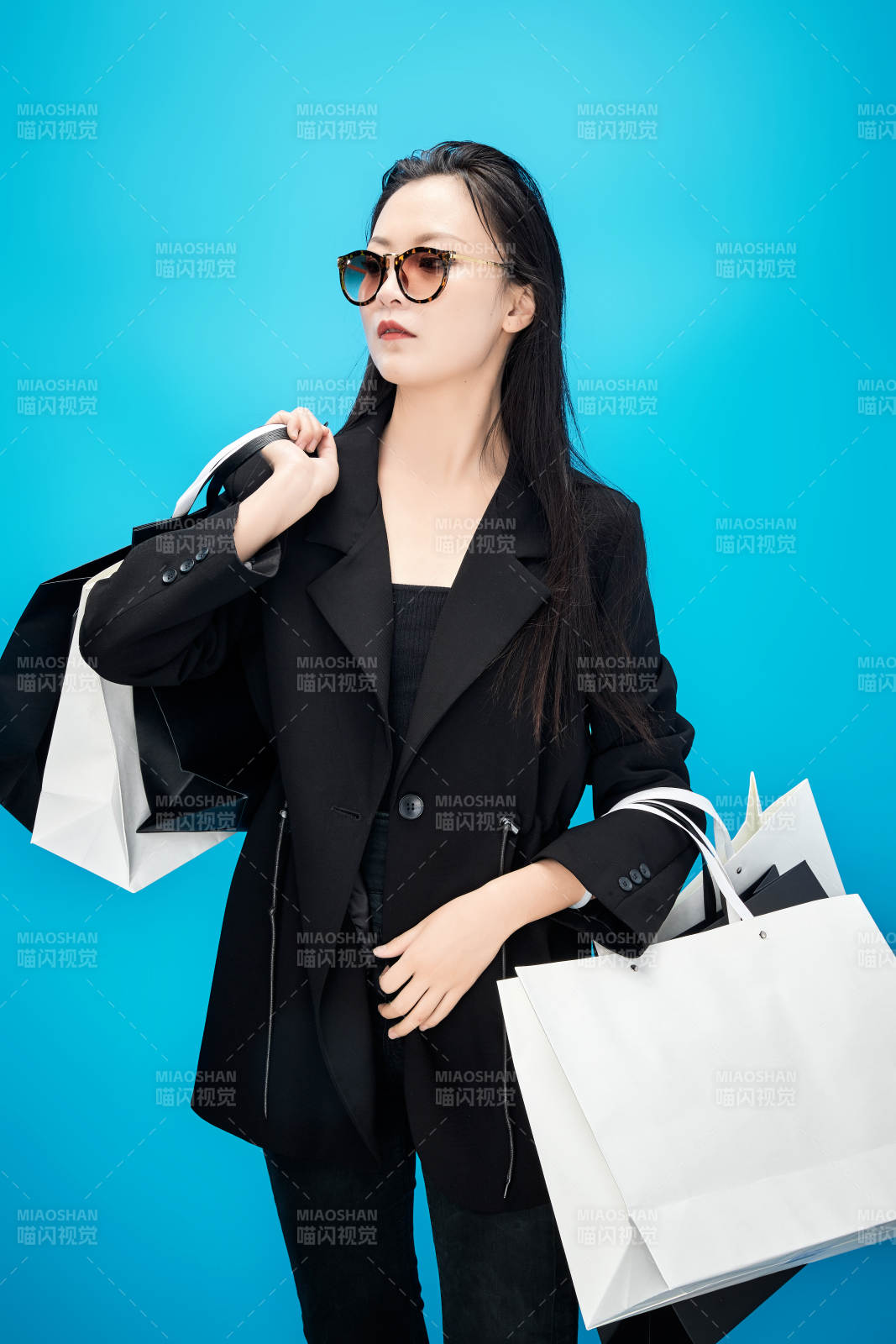 青蓝色背景下手提购物袋的亚洲时尚少女图片