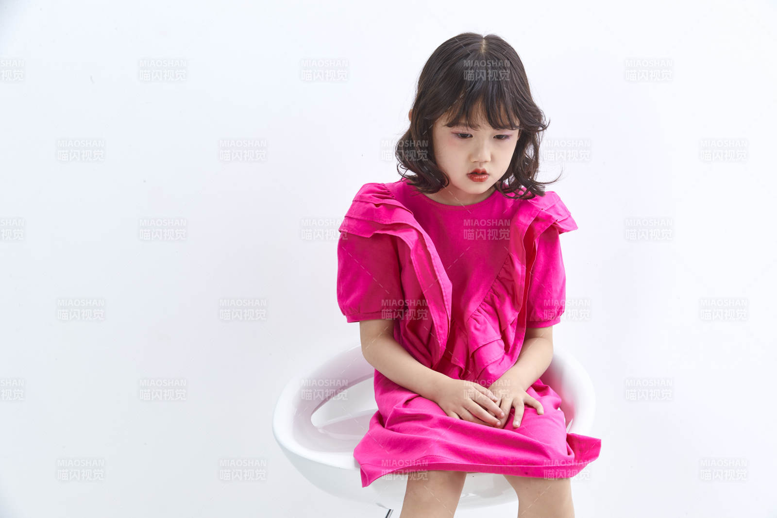 白色背景里坐在凳子上的可爱的亚洲小女孩儿童图片