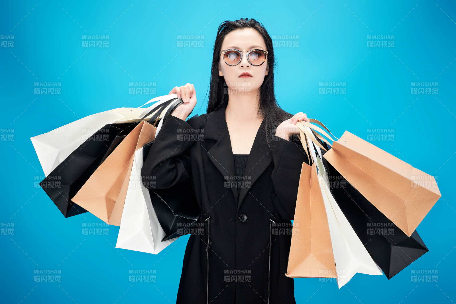 青蓝色背景下手提购物袋的亚洲时尚少女图片