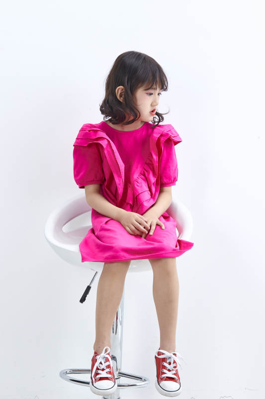 白色背景里坐在凳子上的可爱的亚洲小女孩儿童图片