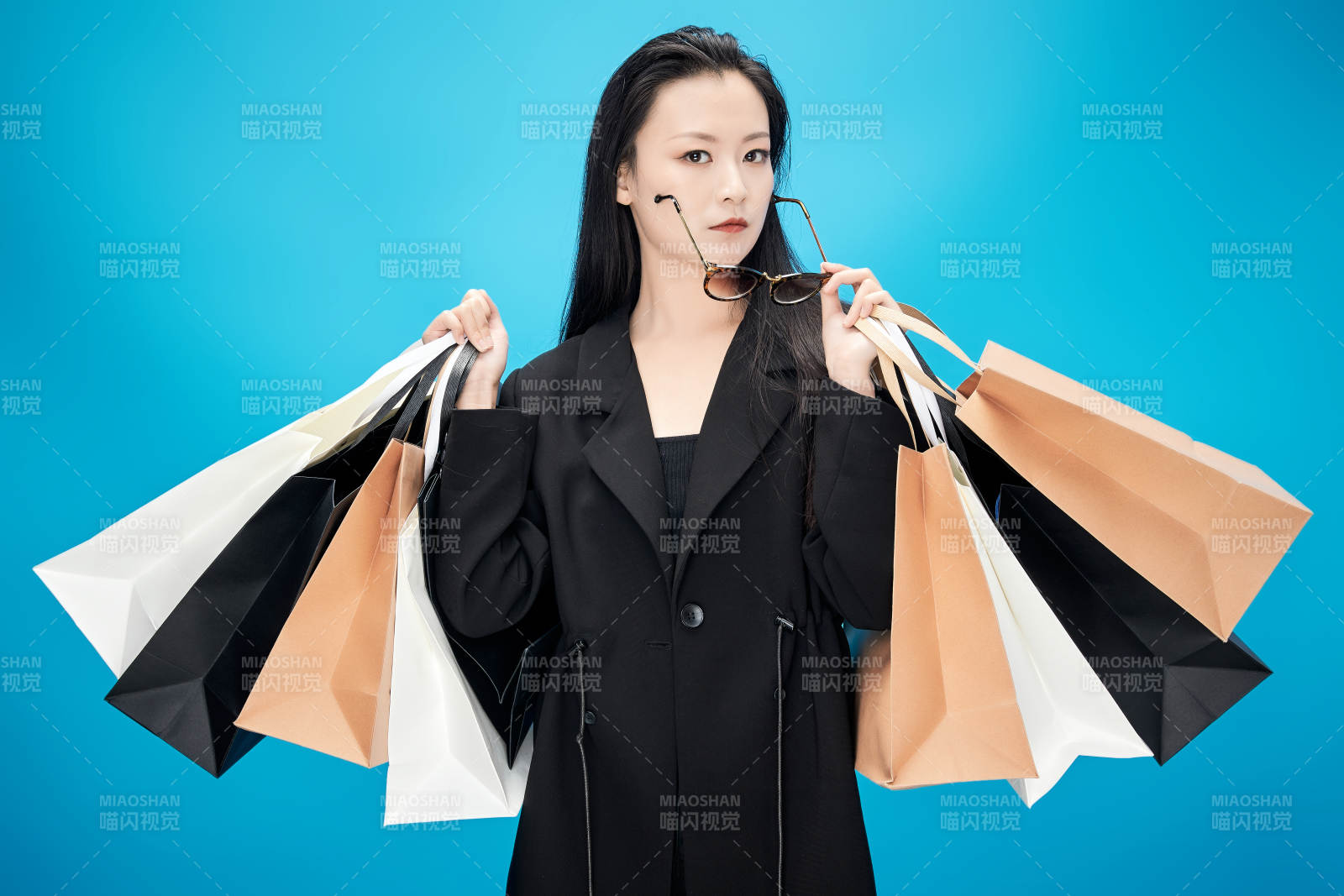 青蓝色背景下手提购物袋的亚洲时尚少女图片