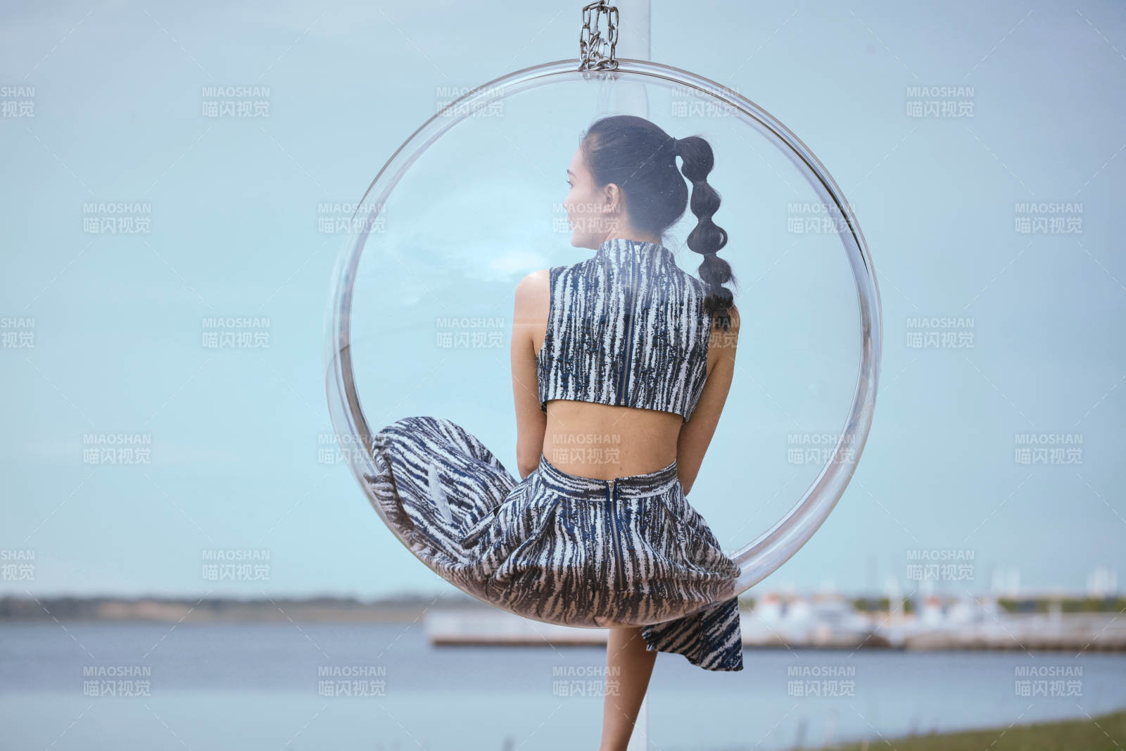 草原湖畔坐在透明秋千里的亚洲年轻女性人像图片