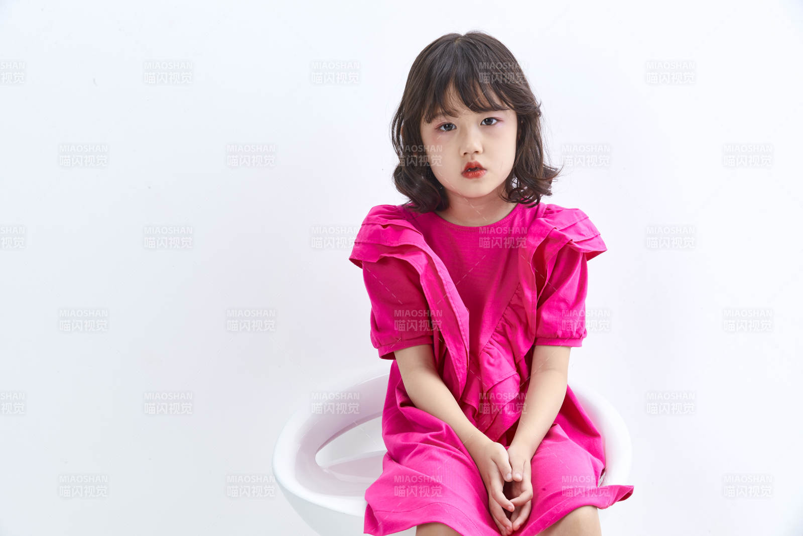 白色背景里坐在凳子上的可爱的亚洲小女孩儿童图片