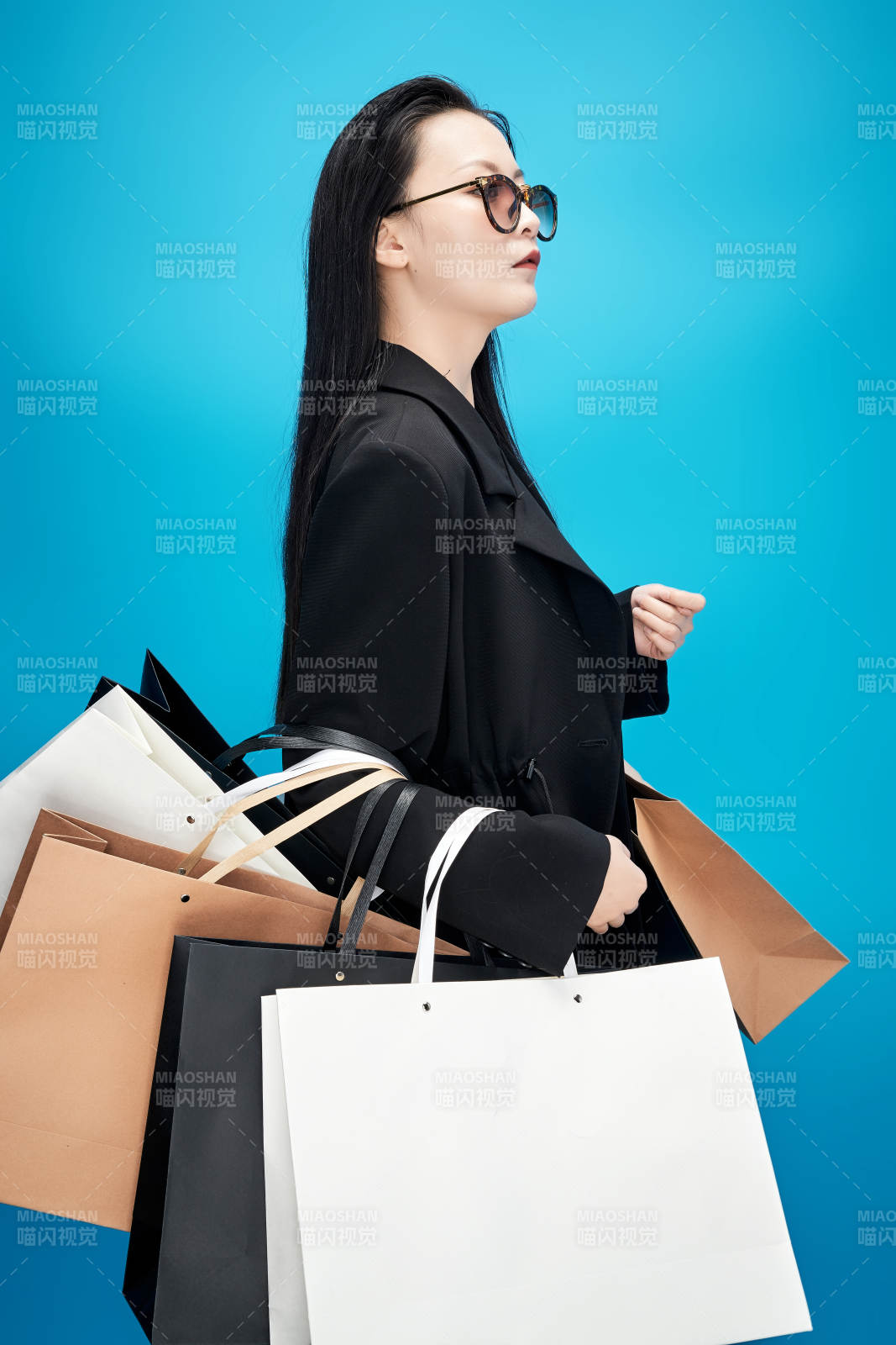 青蓝色背景下手提购物袋的亚洲时尚少女图片