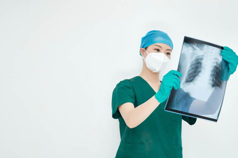 认真查看X光片的外科手术医生图片