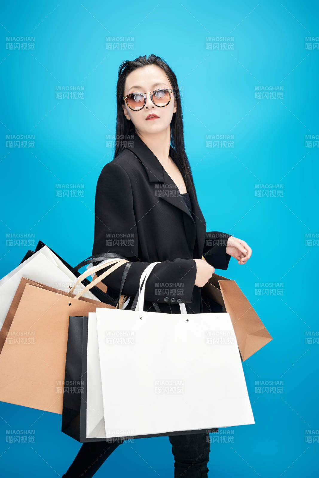 青蓝色背景下手提购物袋的亚洲时尚少女图片