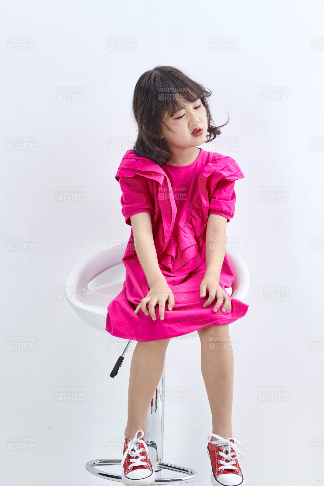 白色背景里坐在凳子上的可爱的亚洲小女孩儿童图片