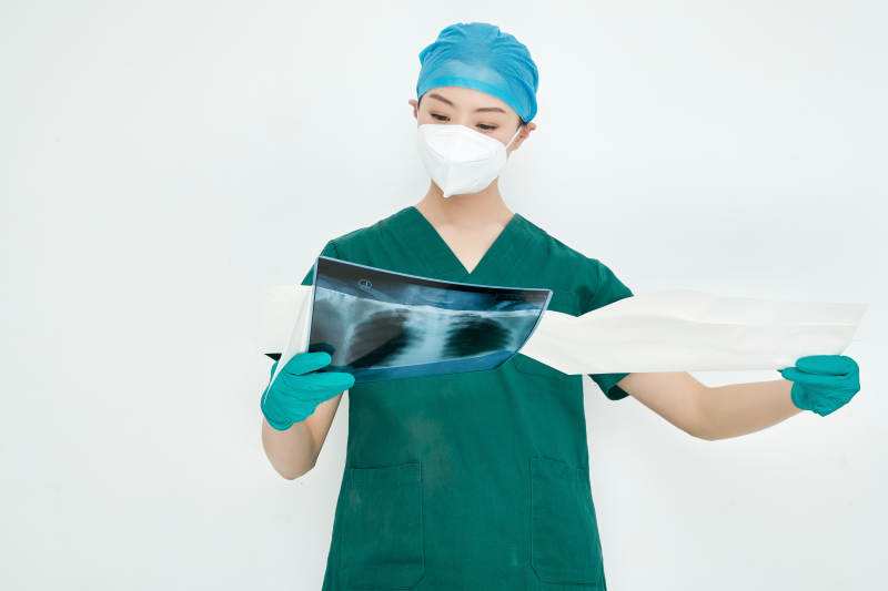 认真查看X光片的外科手术医生图片