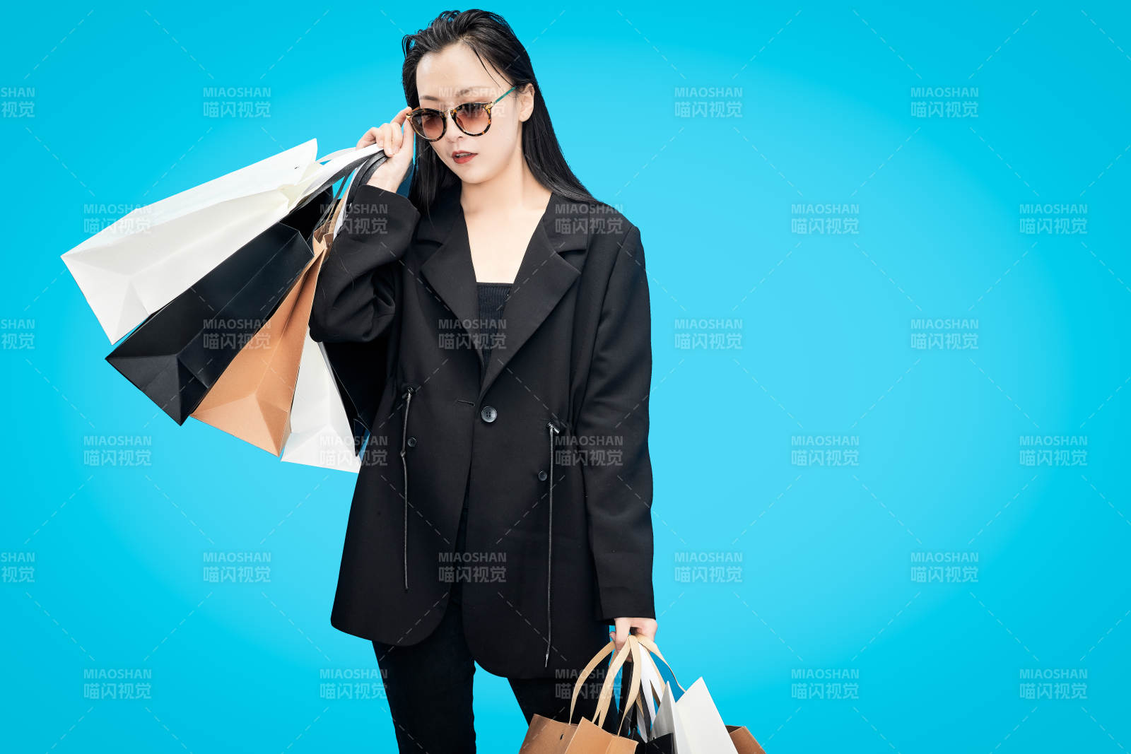 青蓝色背景下手提购物袋的亚洲时尚少女图片