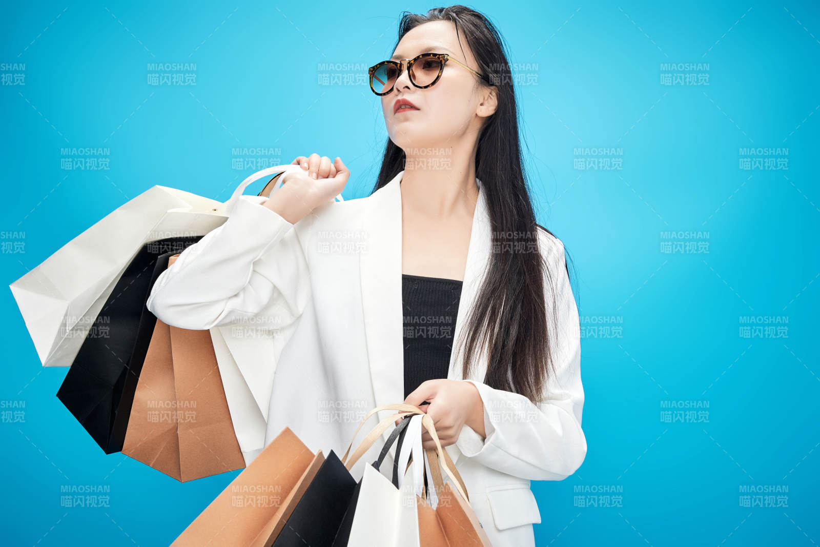 青蓝色背景下手提购物袋的亚洲时尚少女图片