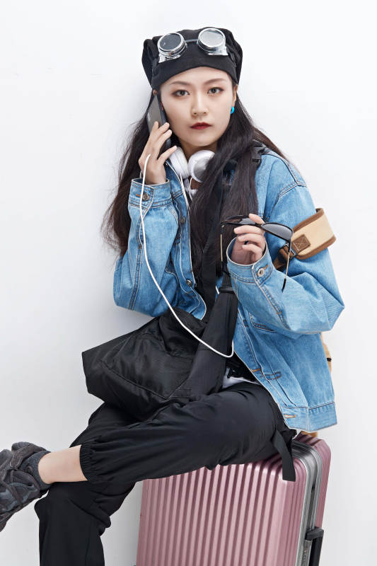 手里拿着手机准备出发的美丽东方女孩图片