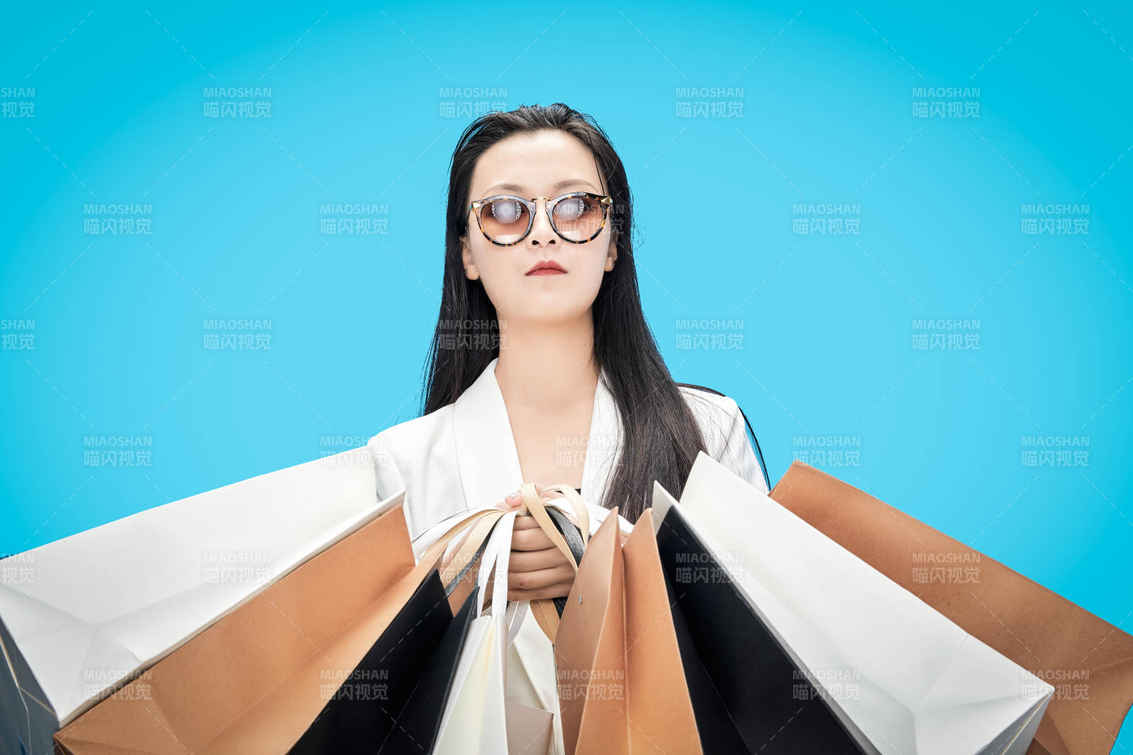 青蓝色背景下手提购物袋的亚洲时尚少女图片