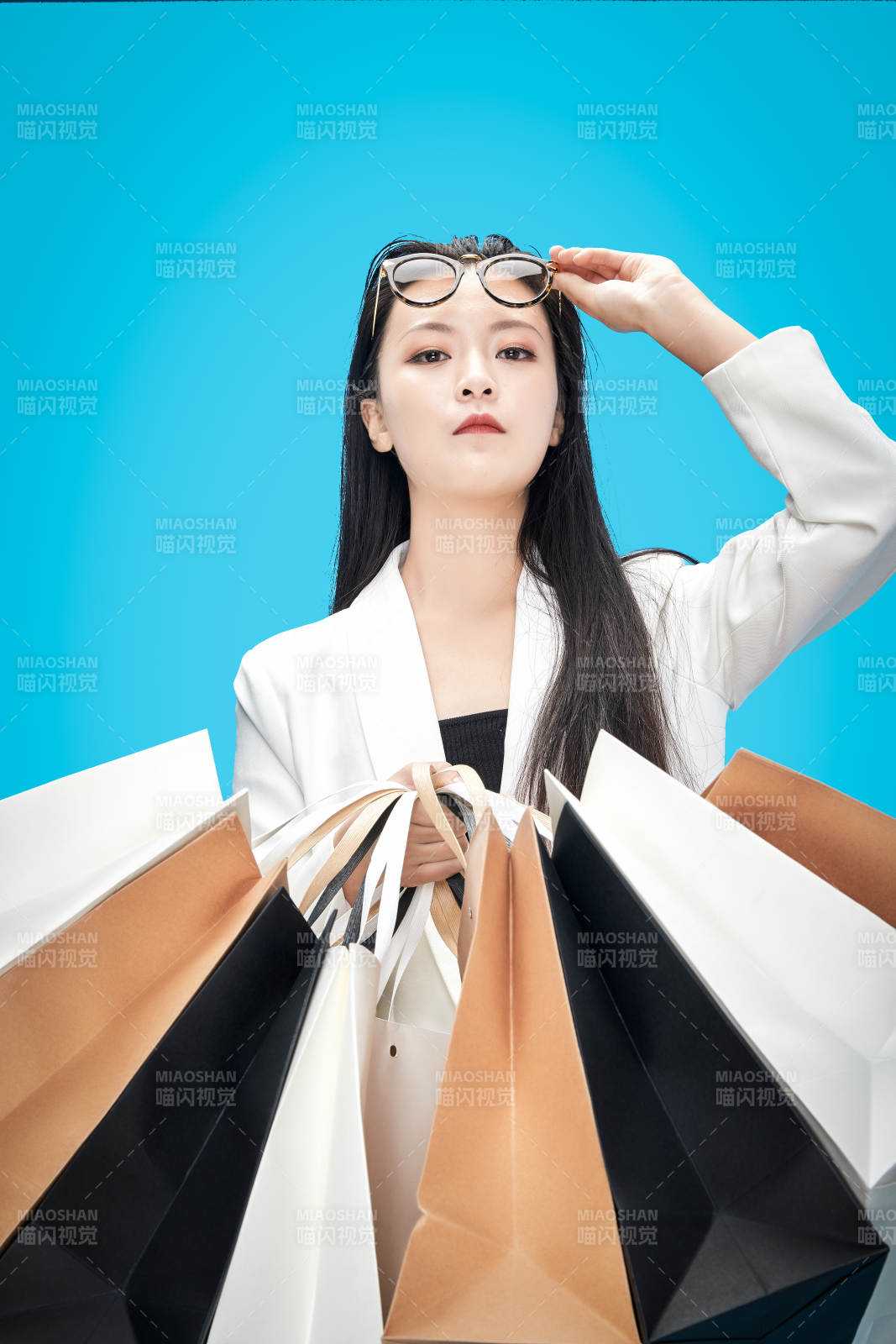 青蓝色背景下手提购物袋的亚洲时尚少女图片