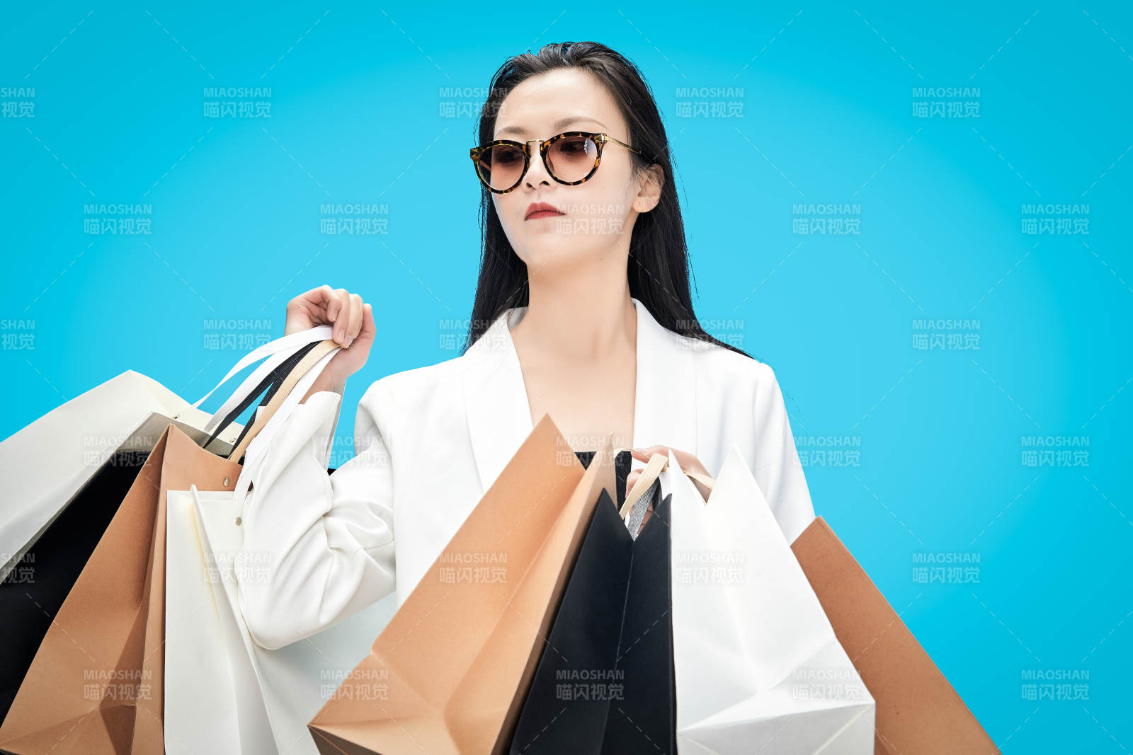 青蓝色背景下手提购物袋的亚洲时尚少女图片