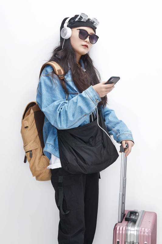 手里拿着手机准备出发的美丽东方女孩图片