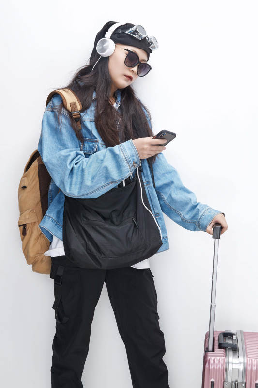 手里拿着手机准备出发的美丽东方女孩图片