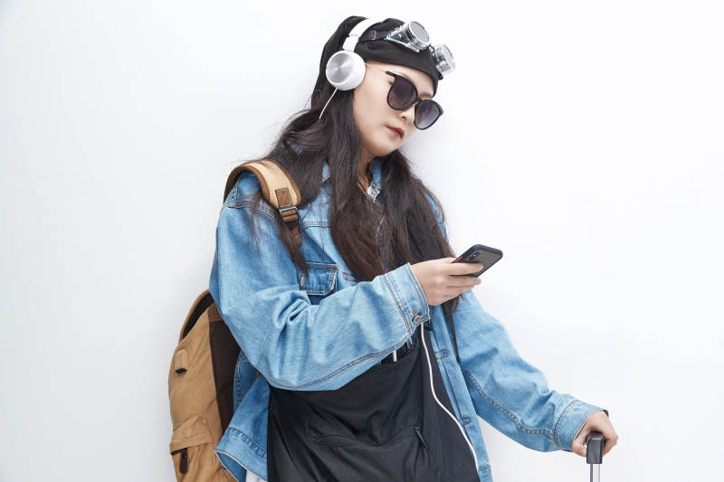 手里拿着手机准备出发的美丽东方女孩图片