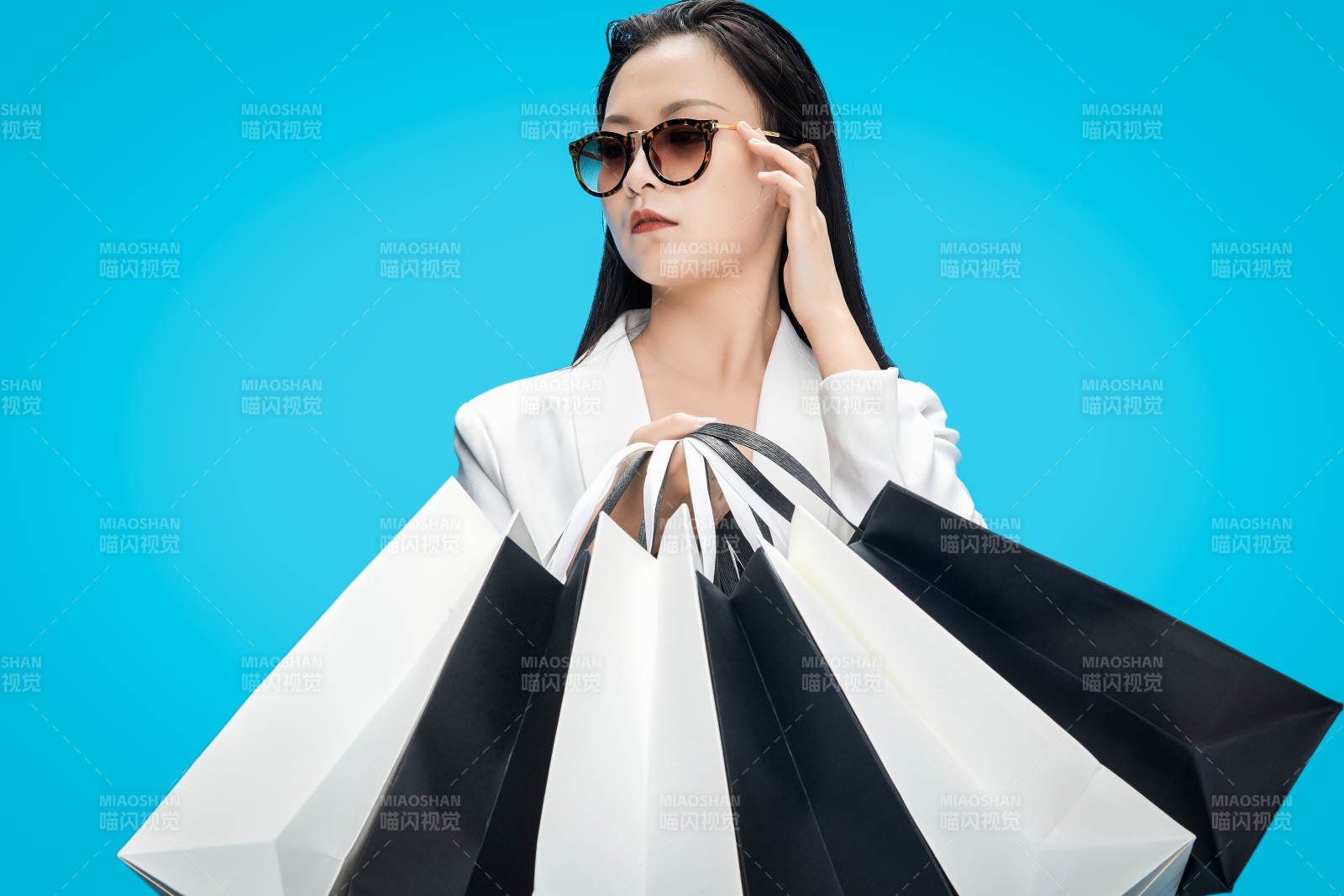 青蓝色背景下手提购物袋的亚洲时尚少女图片