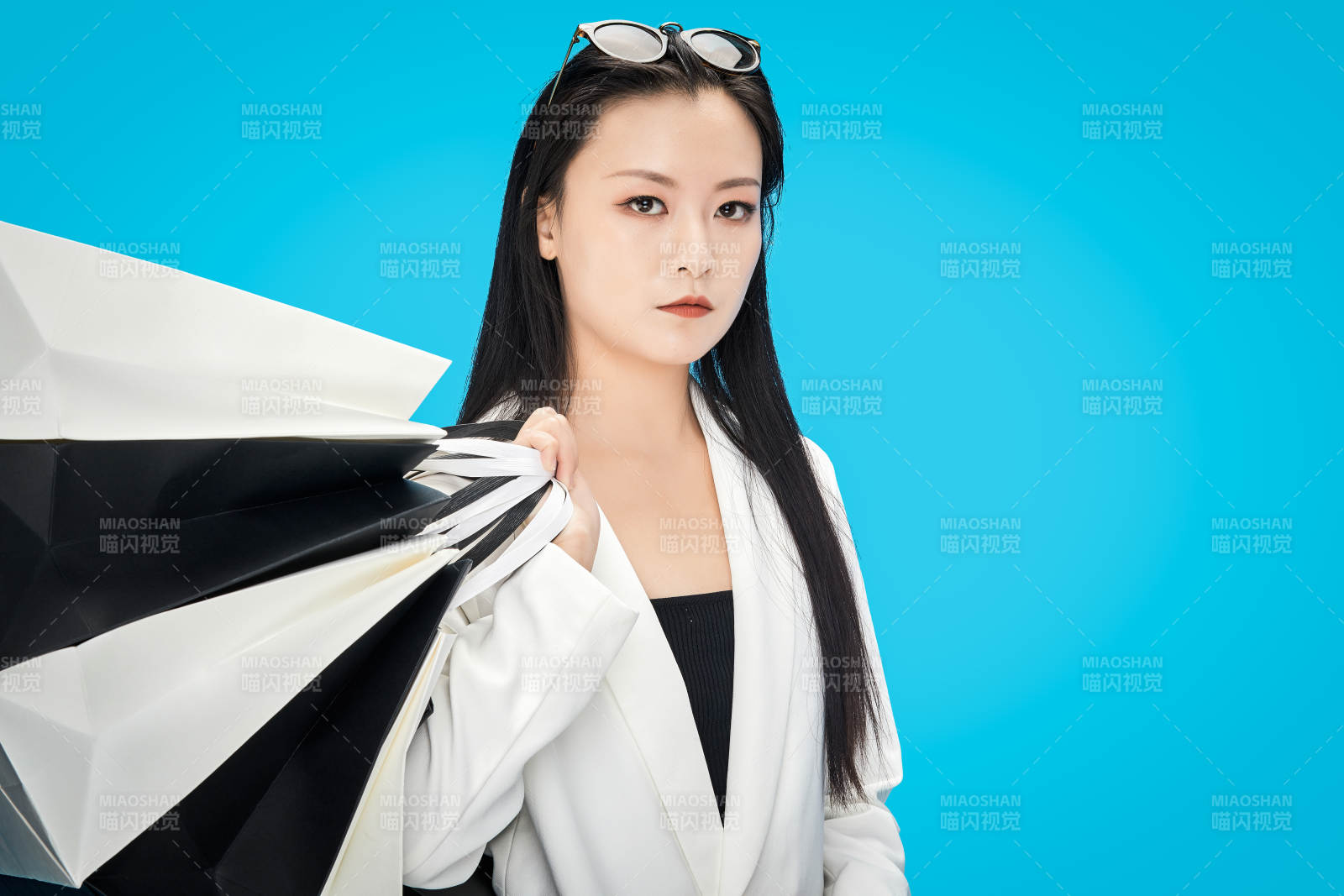 青蓝色背景下手提购物袋的亚洲时尚少女图片