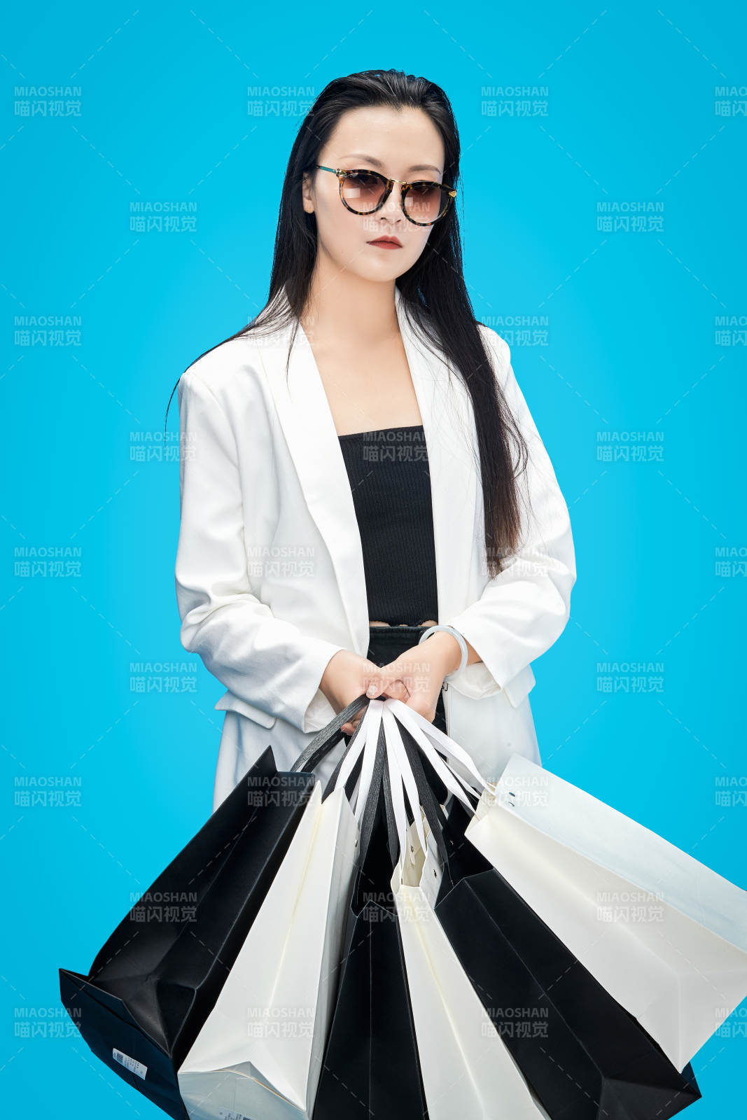 青蓝色背景下手提购物袋的亚洲时尚少女图片