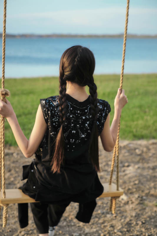 草原湖畔夕阳下荡秋千的亚洲少女图片