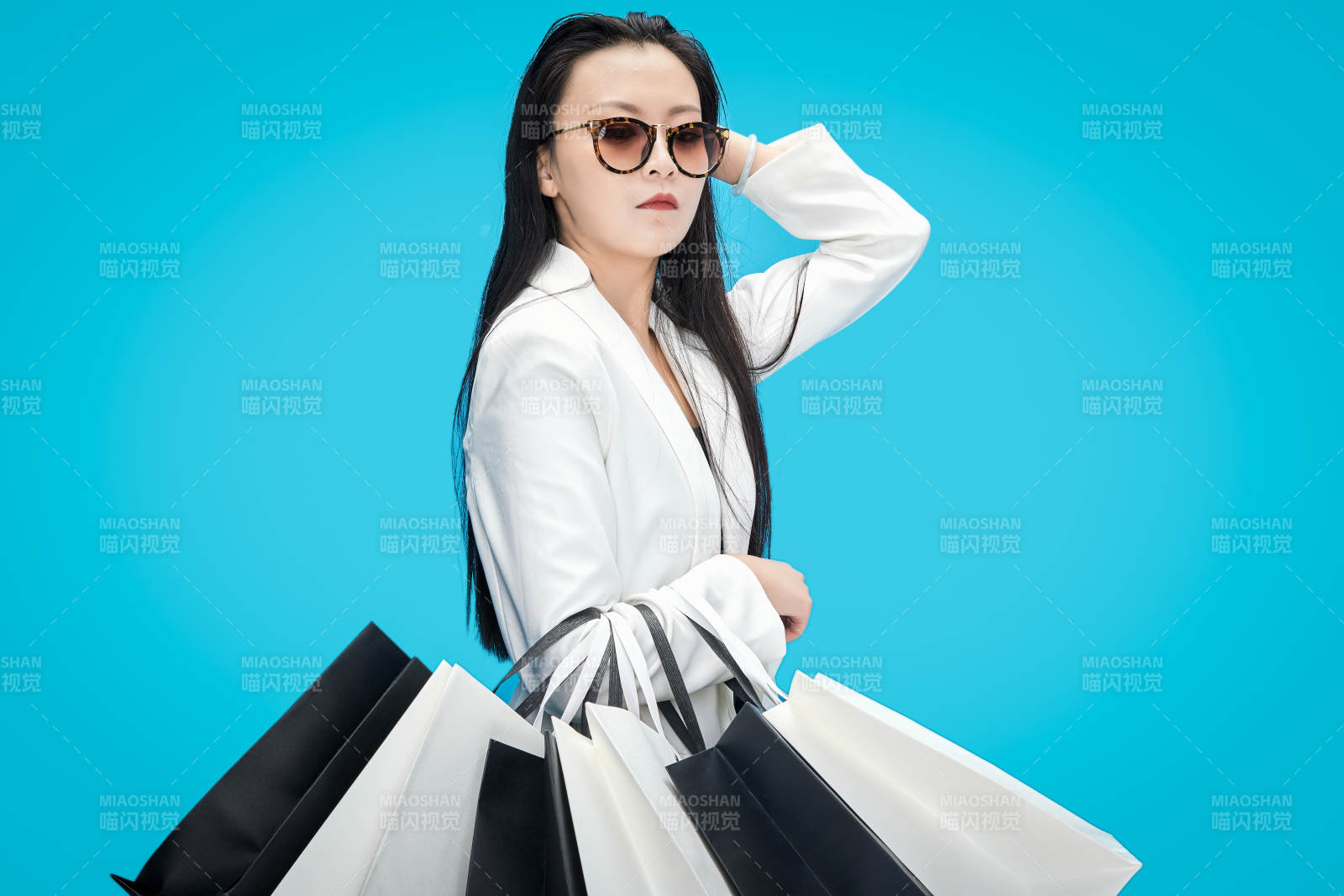 青蓝色背景下手提购物袋的亚洲时尚少女图片