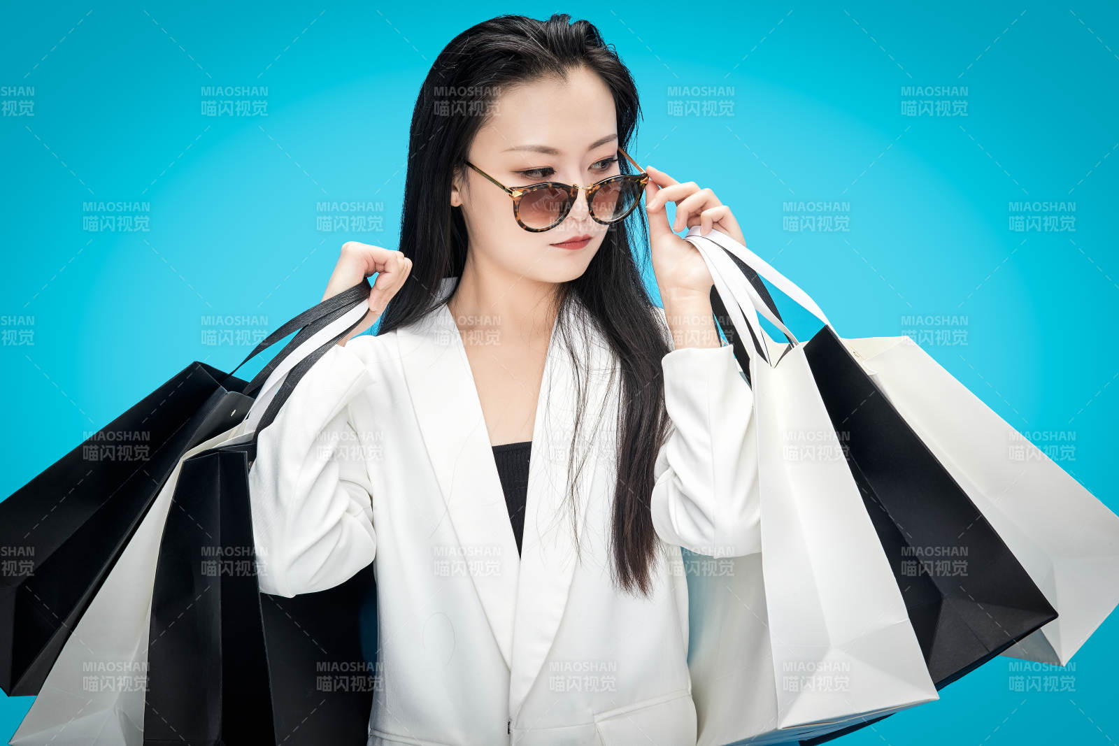 青蓝色背景下手提购物袋的亚洲时尚少女图片